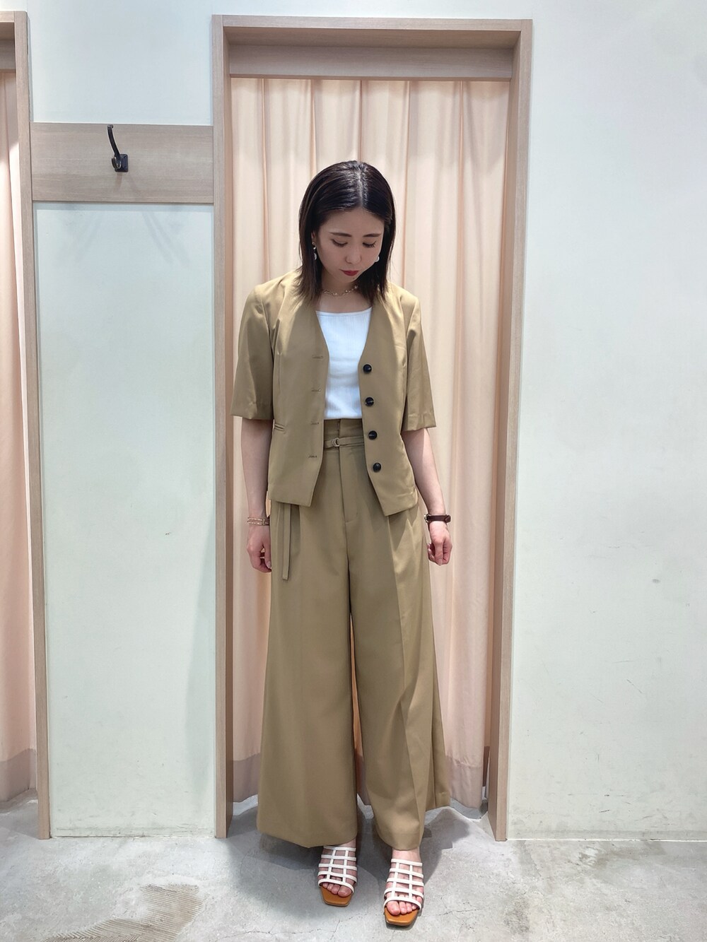 ベージュ系のノーカラージャケット、ベージュ系のその他パンツ、ホワイト系のサンダルを着用したレディースの春コーディネートの2枚目の写真