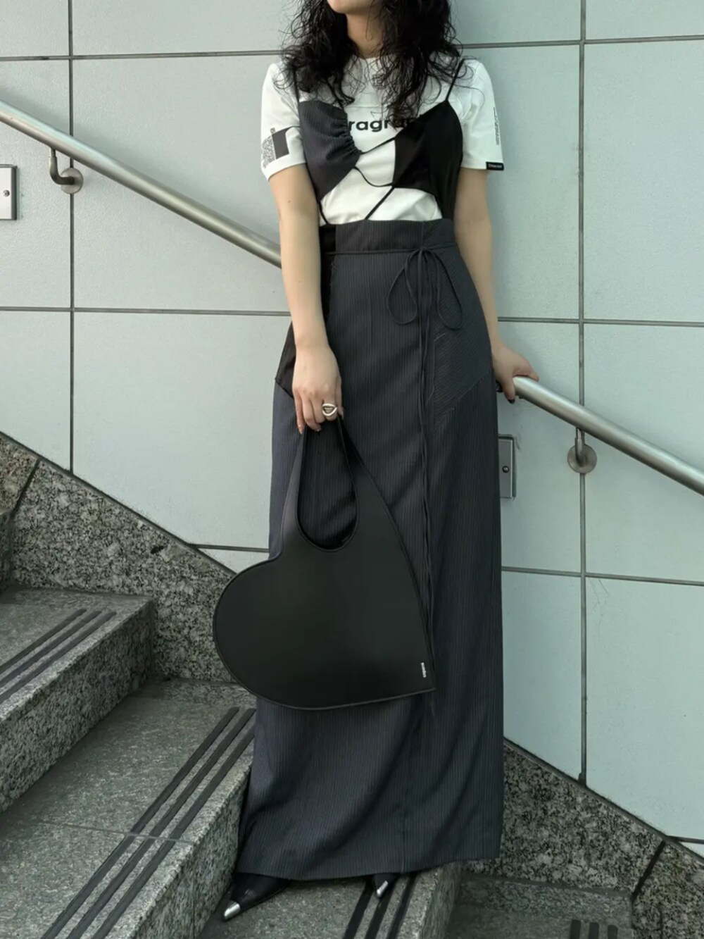 ブルー系のデニムパンツ、ブラック系のシャツ/ブラウスを着用したレディースの春コーディネートの2枚目の写真
