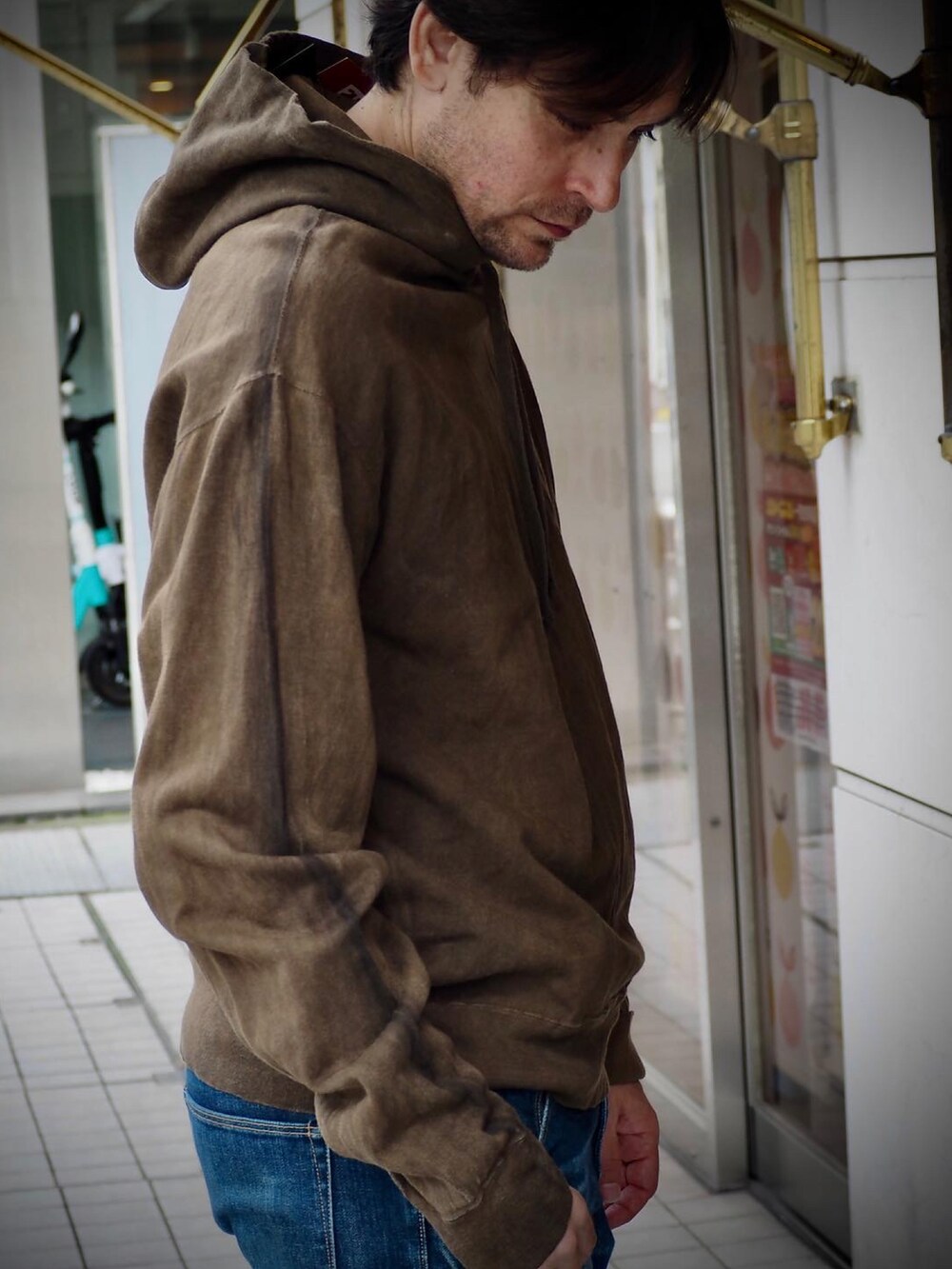 ブラウン系のパーカー、ブルー系のデニムパンツを着用したメンズの春コーディネートの3枚目の写真