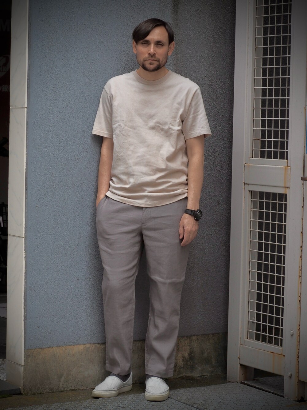 ベージュ系のTシャツ/カットソー、グレー系のその他パンツ、ホワイト系のその他シューズを着用したメンズの春コーディネートの2枚目の写真