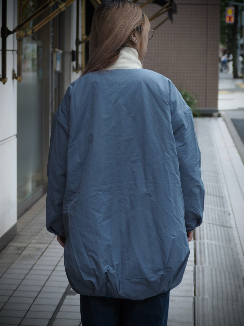 ホワイト系のその他トップス、ブルー系のデニムパンツ、ブルー系のチェスターコートを着用したレディースの秋コーディネートの4枚目の写真
