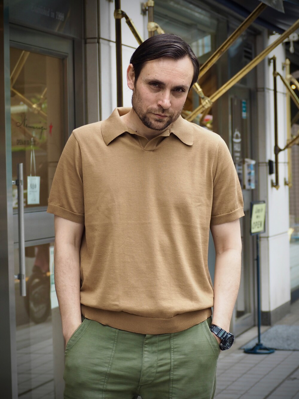 ブラウン系のポロシャツ、ブラック系のデジタル腕時計を着用したメンズの春コーディネートの3枚目の写真