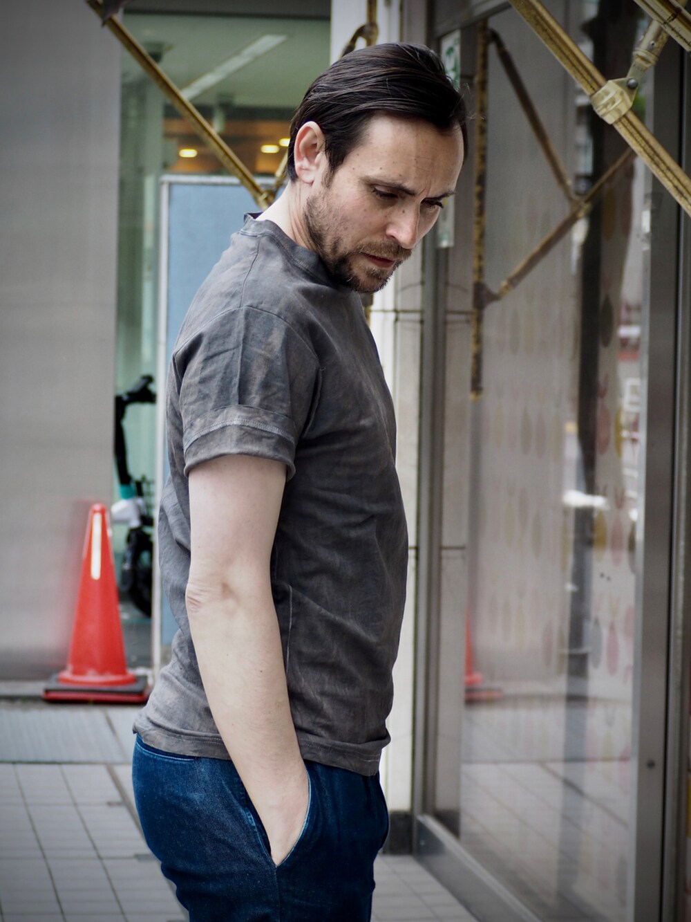 グレー系のTシャツ/カットソー、ブルー系のデニムパンツ、ブラック系のデジタル腕時計を着用したメンズの春コーディネートの3枚目の写真