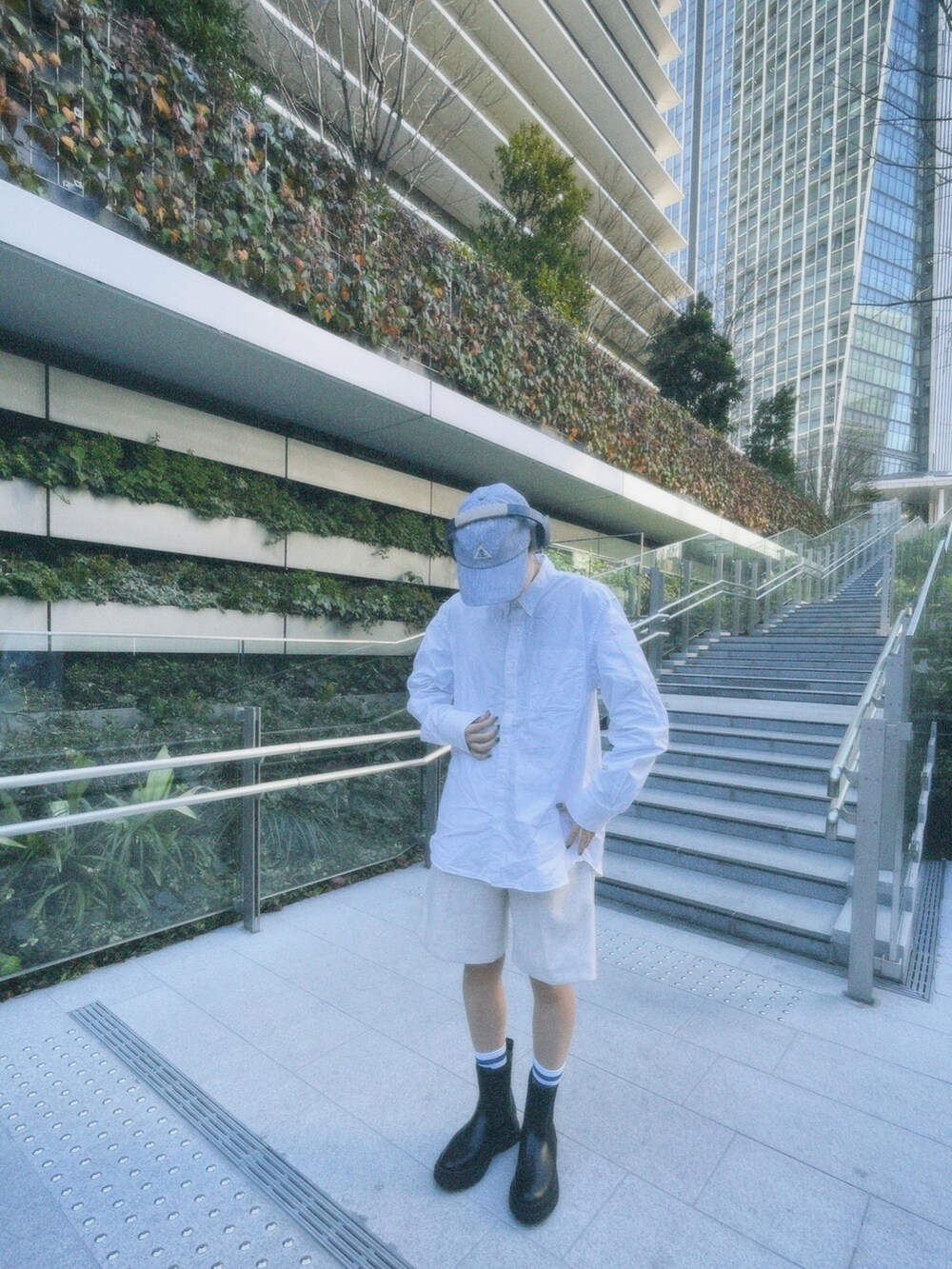 ブルー系のキャップを着用したレディースの春コーディネートの2枚目の写真