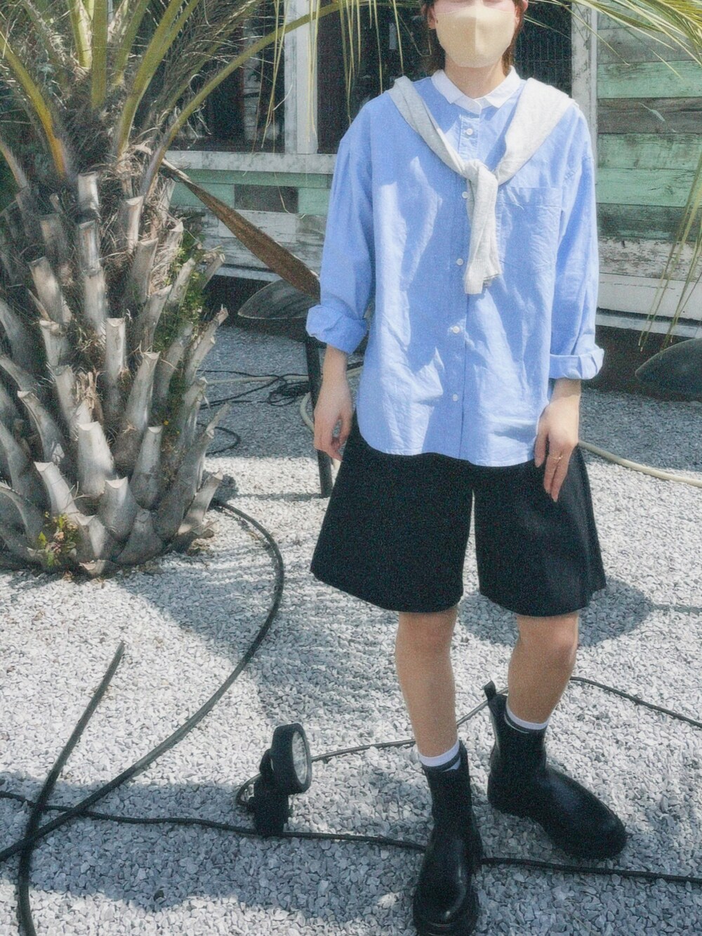 ブルー系のシャツ/ブラウス、ブラック系のパンツ、ブラウン系のニットキャップ/ビーニーを着用したレディースの春コーディネートの2枚目の写真