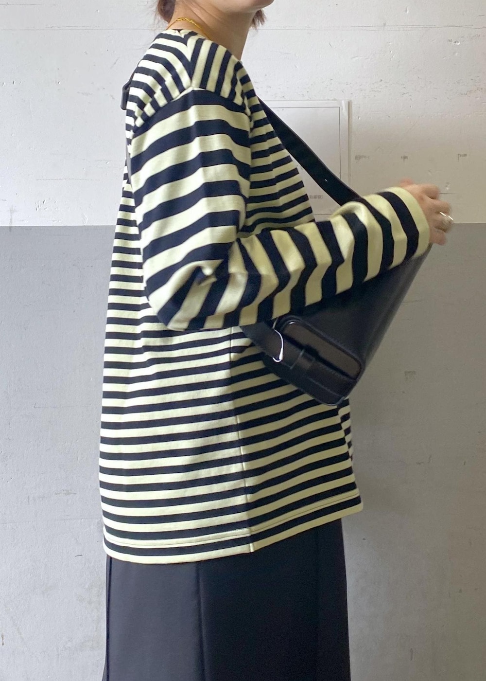 ブラック系のハンドバッグ、ブラック系のローファー、グリーン系のTシャツ/カットソーを着用したレディースの冬コーディネートの8枚目の写真