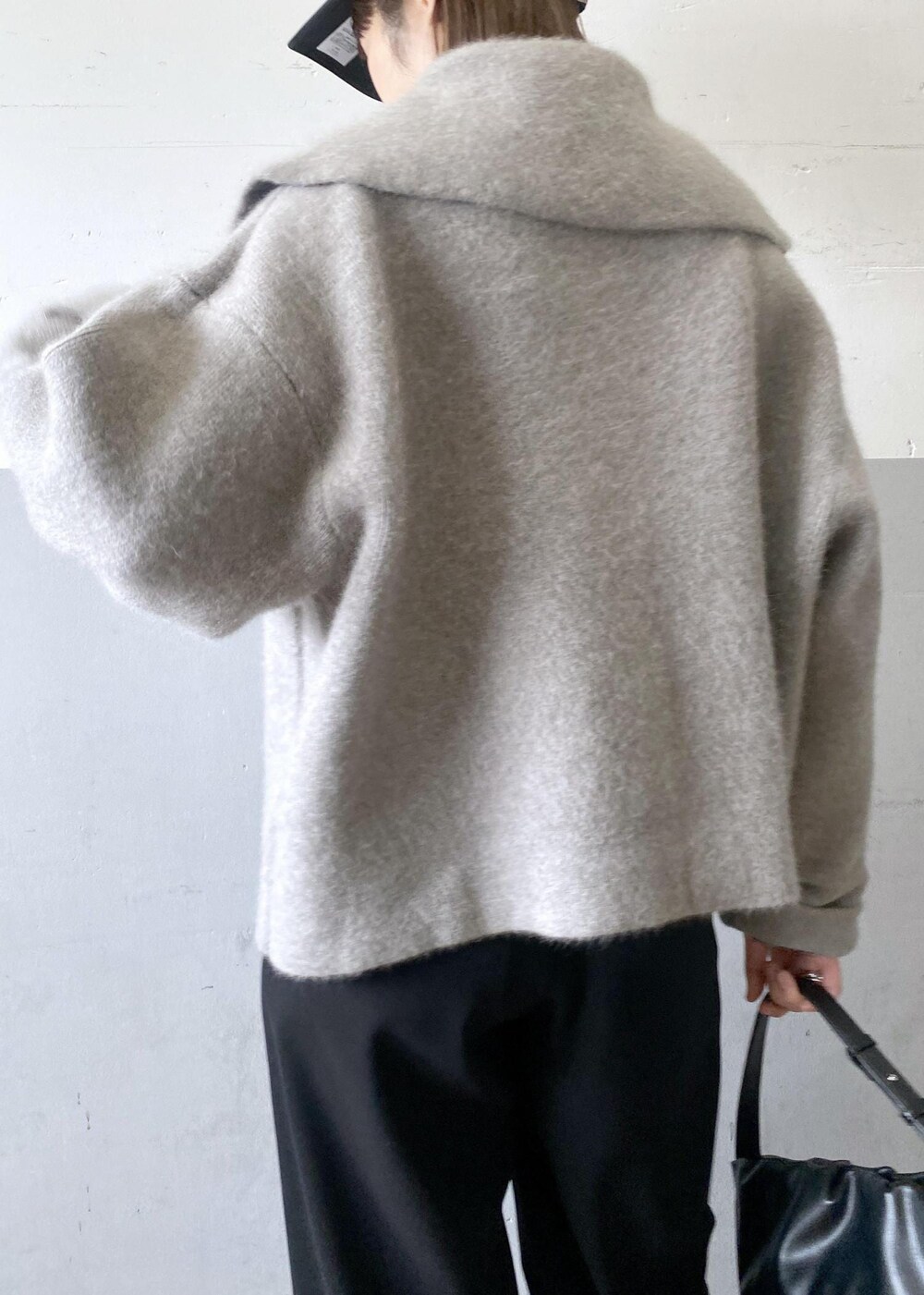 ブラック系のニット/セーター、ベージュ系のカーディガン/ボレロ、ブラック系のハンドバッグを着用したレディースの秋コーディネートの8枚目の写真