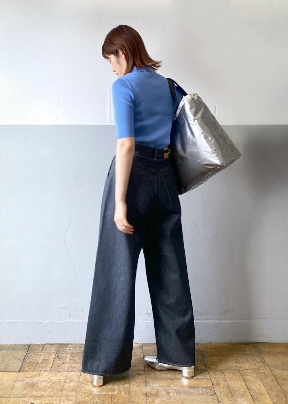 シルバー系のパンプス、ブラック系のデニムパンツ、ブラック系のトートバッグを着用したレディースの春コーディネートの7枚目の写真