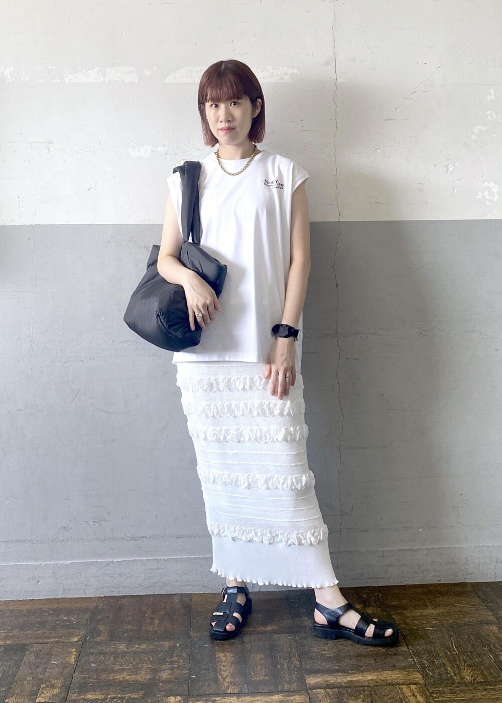 ブラック系のサンダル、ホワイト系のスカート、ホワイト系のTシャツ/カットソーを着用したレディースの夏コーディネートの3枚目の写真