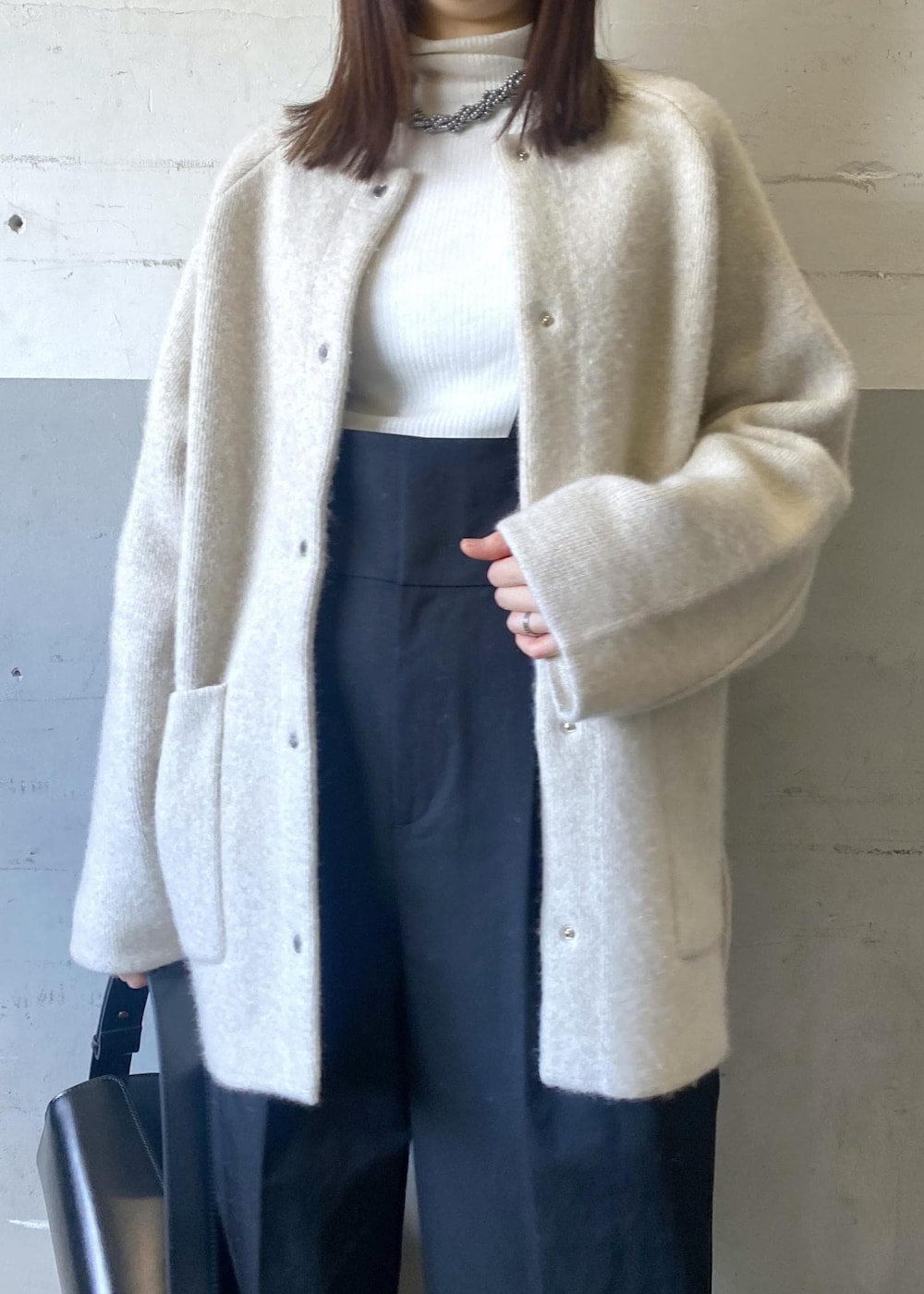 ホワイト系のカーディガン/ボレロ、ホワイト系のニット/セーター、ブラック系のハンドバッグを着用したレディースの冬コーディネートの9枚目の写真