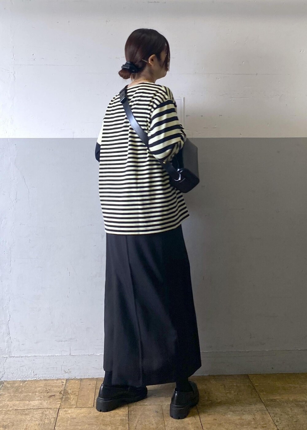 ブラック系のハンドバッグ、ブラック系のローファー、グリーン系のTシャツ/カットソーを着用したレディースの冬コーディネートの4枚目の写真