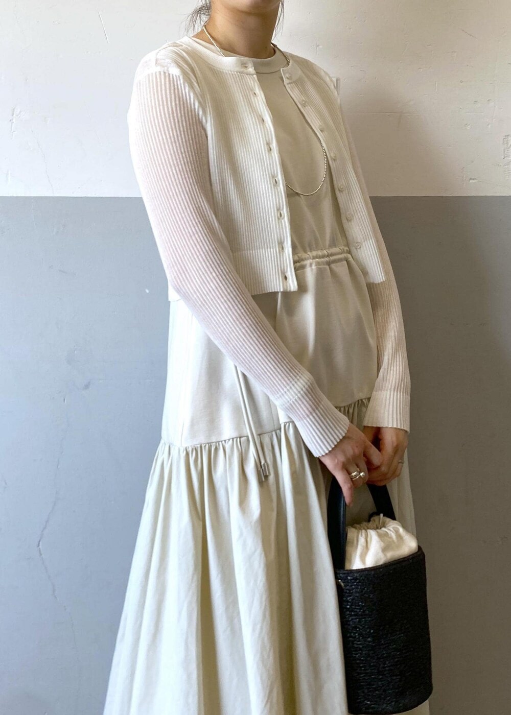 シルバー系のサンダル、ホワイト系のカーディガン/ボレロ、ブラック系のハンドバッグを着用したレディースの夏コーディネートの5枚目の写真