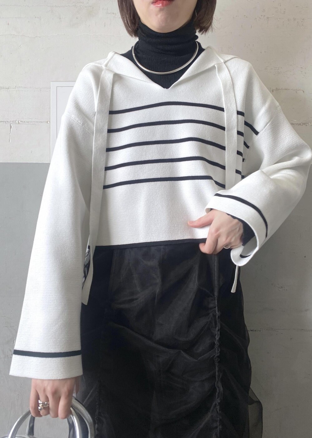 シルバー系のボストンバッグ、ブラック系のニット/セーターを着用したレディースの冬コーディネートの6枚目の写真