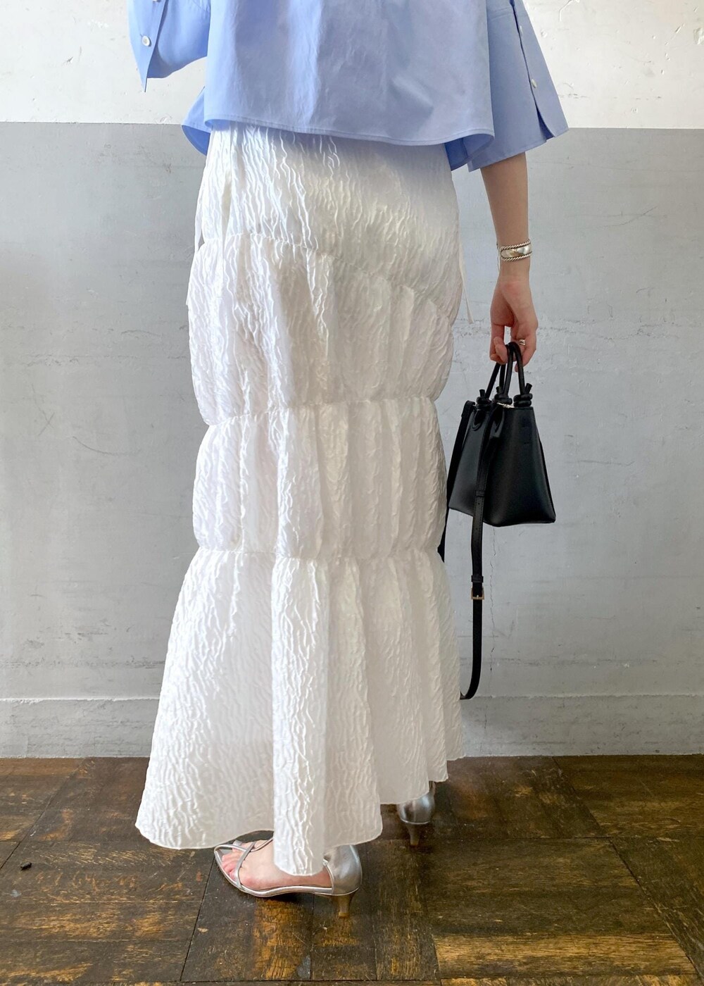 シルバー系のサンダル、ホワイト系のスカート、ブラック系のハンドバッグを着用したレディースの夏コーディネートの10枚目の写真