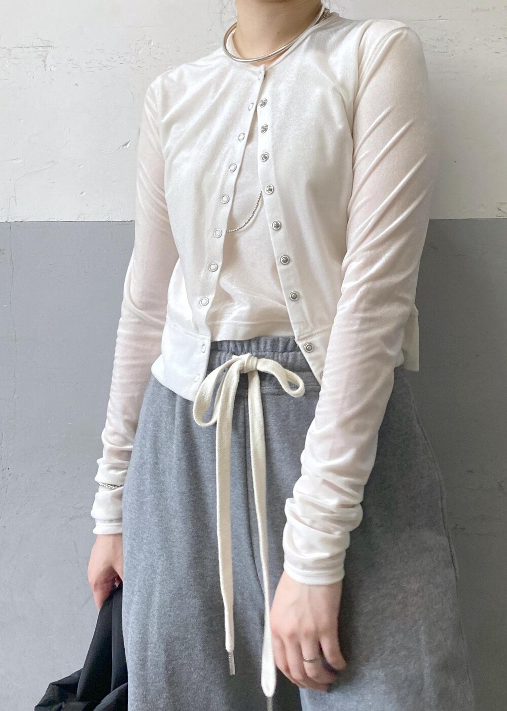 ブラック系のパンプス、ホワイト系のカーディガン/ボレロ、グレー系のスウェットパンツを着用したレディースの秋コーディネートの6枚目の写真