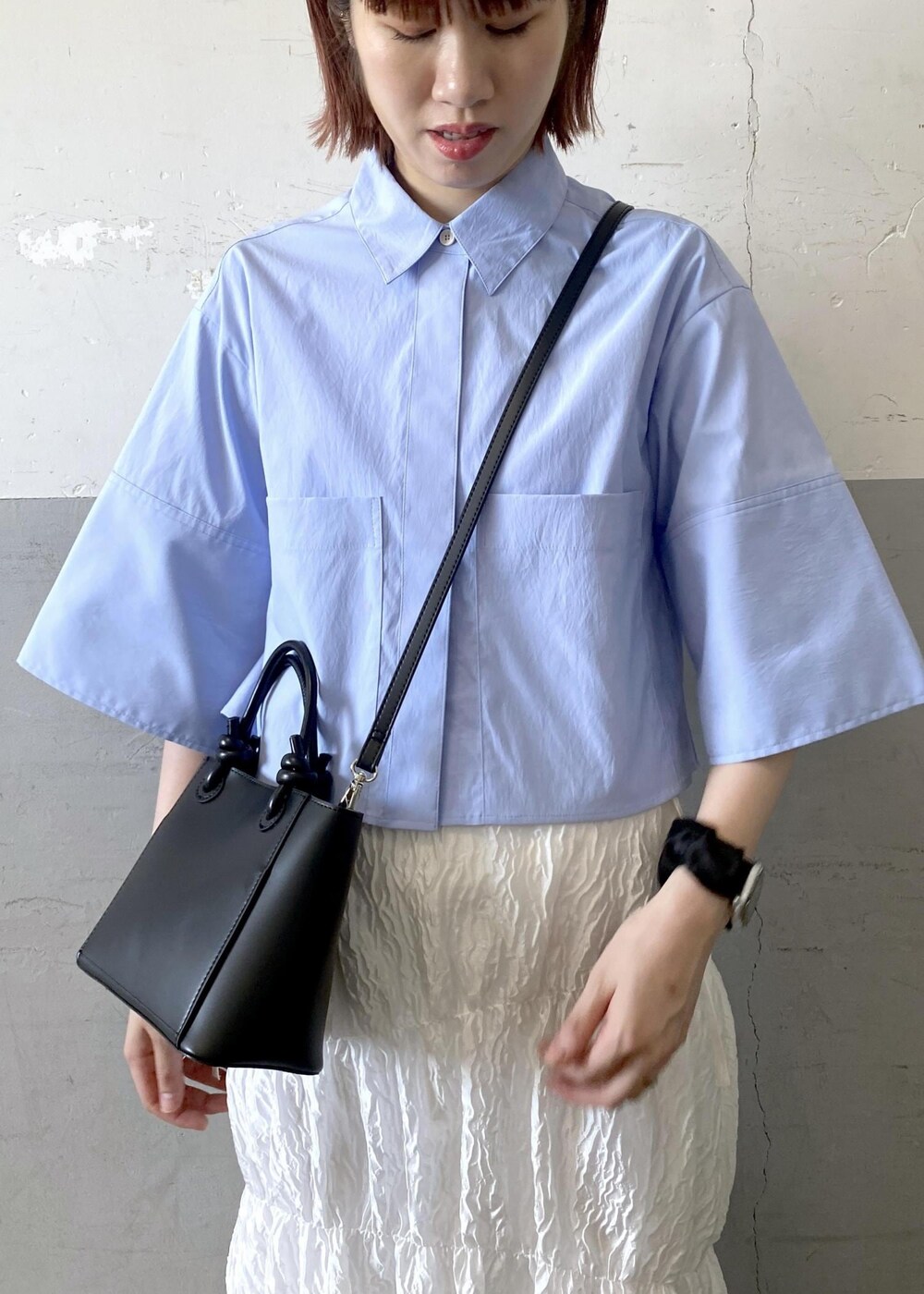 シルバー系のサンダル、ホワイト系のスカート、ブラック系のハンドバッグを着用したレディースの夏コーディネートの6枚目の写真