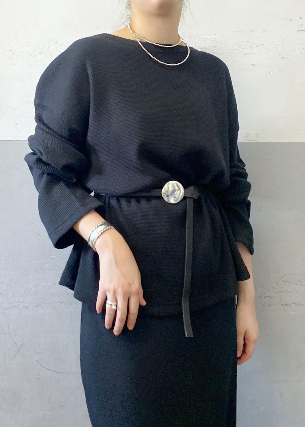 ホワイト系のショルダーバッグ、ブラック系のTシャツ/カットソー、ブラック系のスカートを着用したレディースの秋コーディネートの6枚目の写真