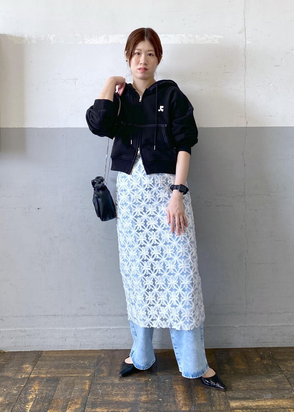 ブラック系のショルダーバッグ、ホワイト系のスカートを着用したレディースの夏コーディネートの2枚目の写真