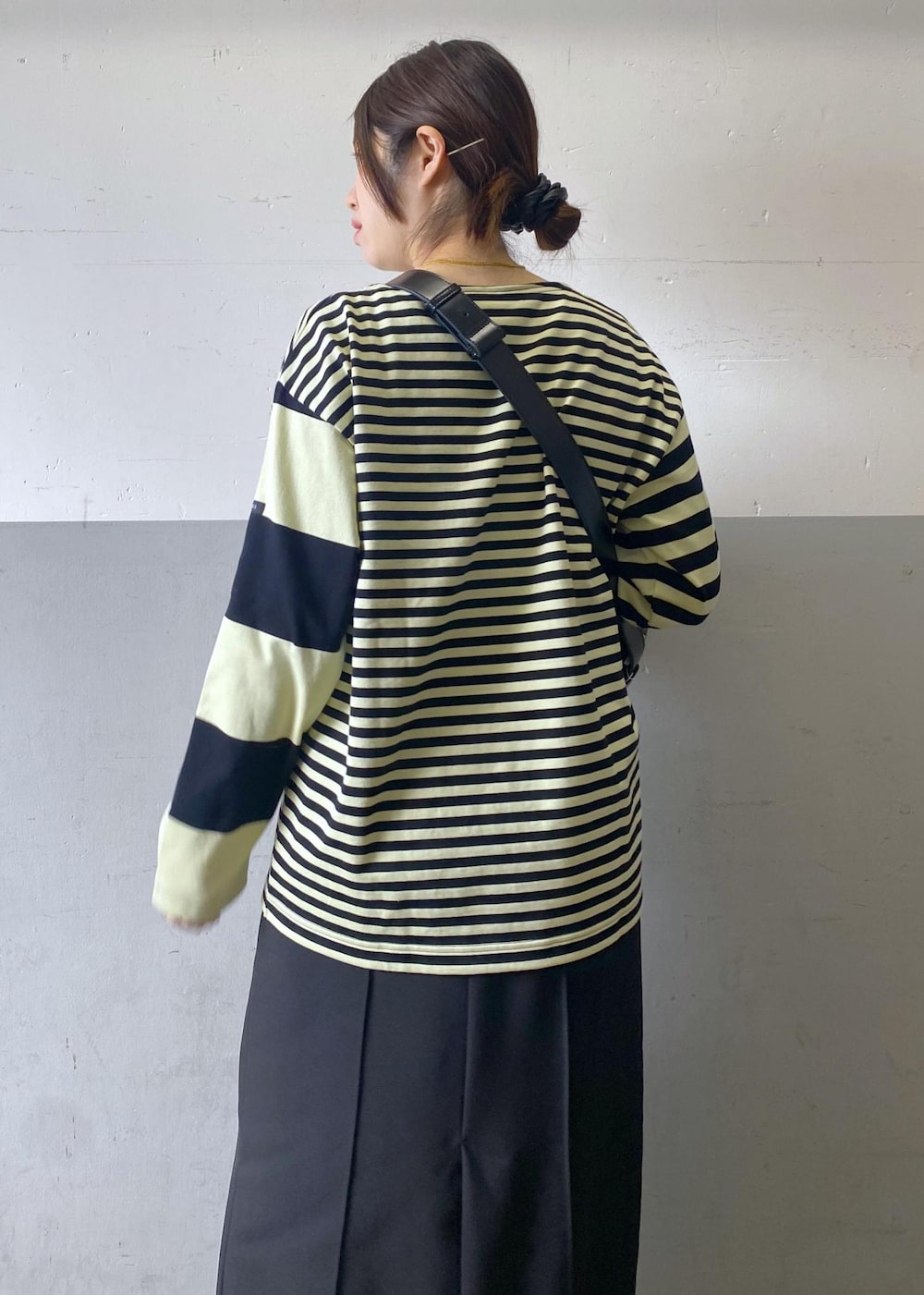 ブラック系のハンドバッグ、ブラック系のローファー、グリーン系のTシャツ/カットソーを着用したレディースの冬コーディネートの7枚目の写真