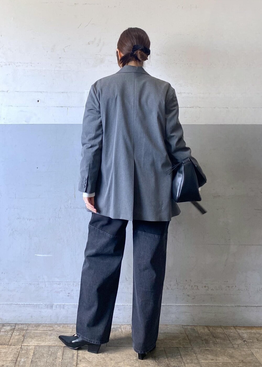 グレー系のテーラードジャケット、ブラック系のパンプス、ブラック系のショルダーバッグを着用したレディースの冬コーディネートの5枚目の写真