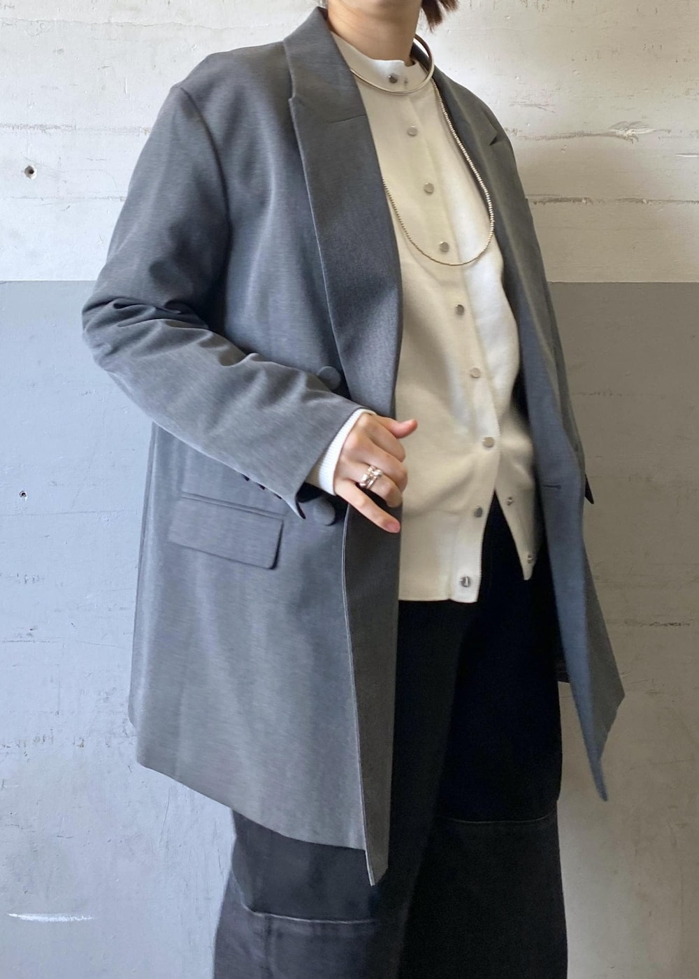 グレー系のテーラードジャケット、ブラック系のパンプス、ブラック系のショルダーバッグを着用したレディースの冬コーディネートの9枚目の写真