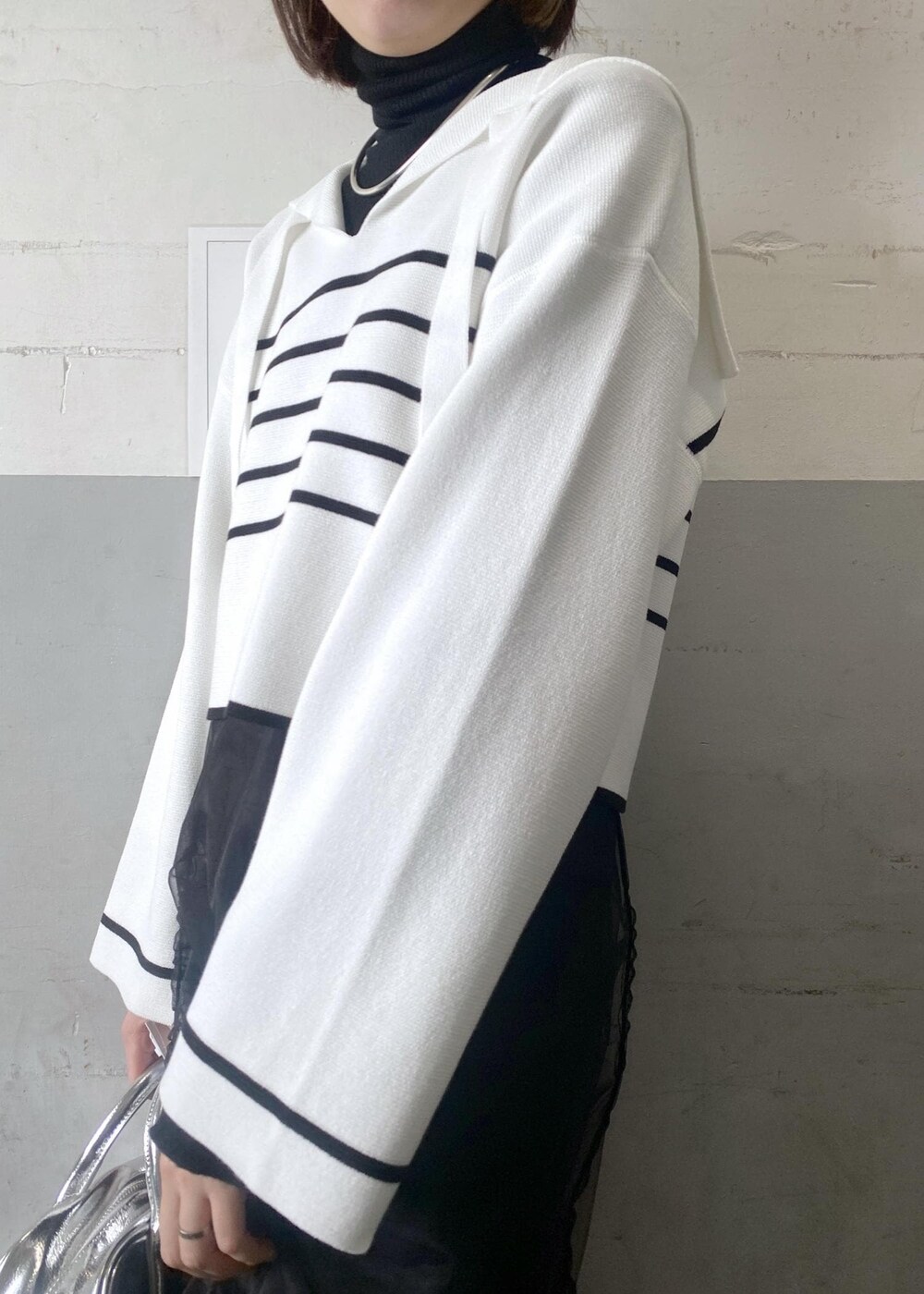 シルバー系のボストンバッグ、ブラック系のニット/セーターを着用したレディースの冬コーディネートの7枚目の写真