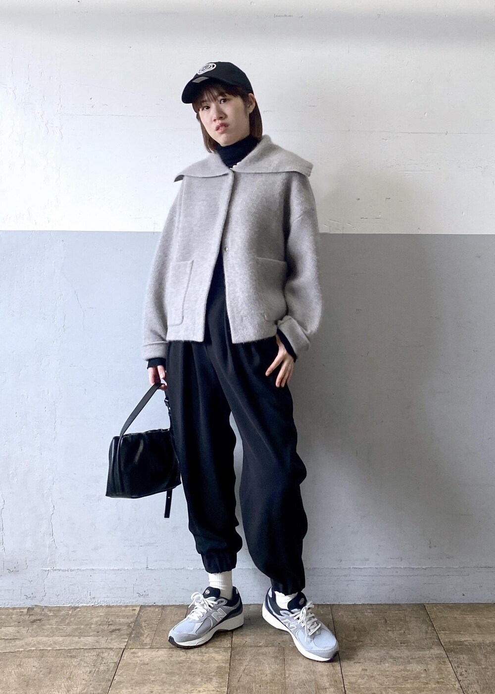 ブラック系のニット/セーター、ベージュ系のカーディガン/ボレロ、ブラック系のハンドバッグを着用したレディースの秋コーディネートの3枚目の写真