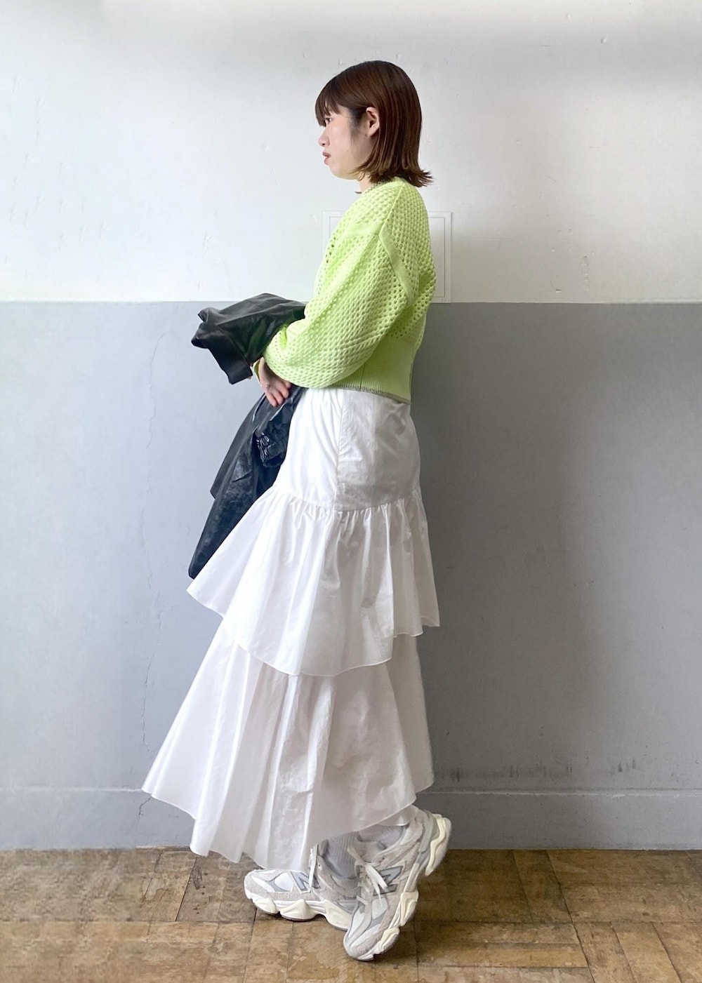 ホワイト系のスカート、ブラック系のブルゾン、グリーン系のニット/セーターを着用したレディースの春コーディネートの4枚目の写真
