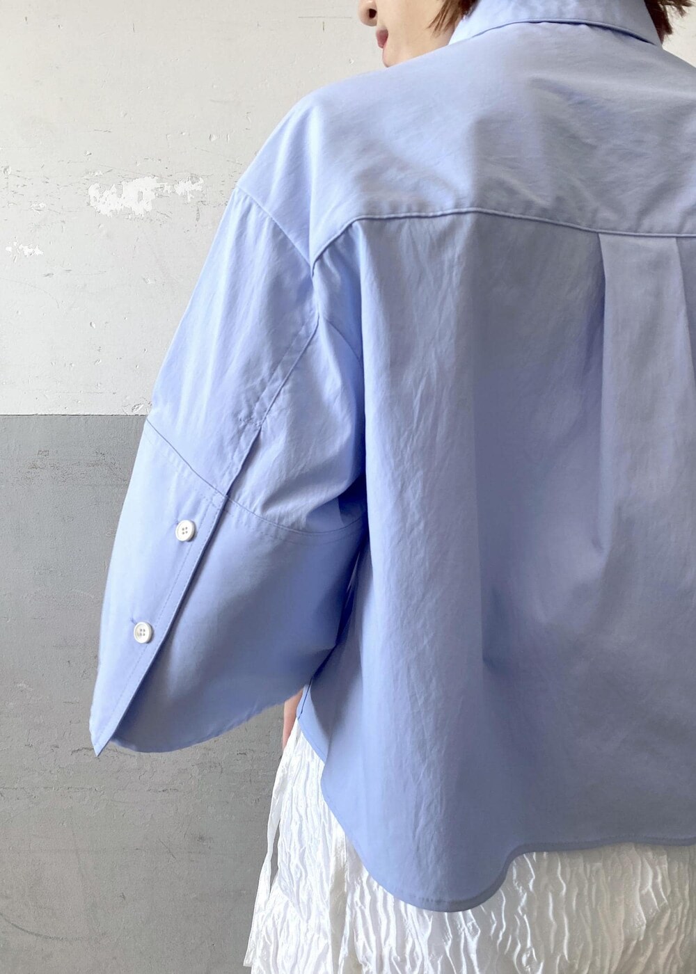 シルバー系のサンダル、ホワイト系のスカート、ブラック系のハンドバッグを着用したレディースの夏コーディネートの7枚目の写真