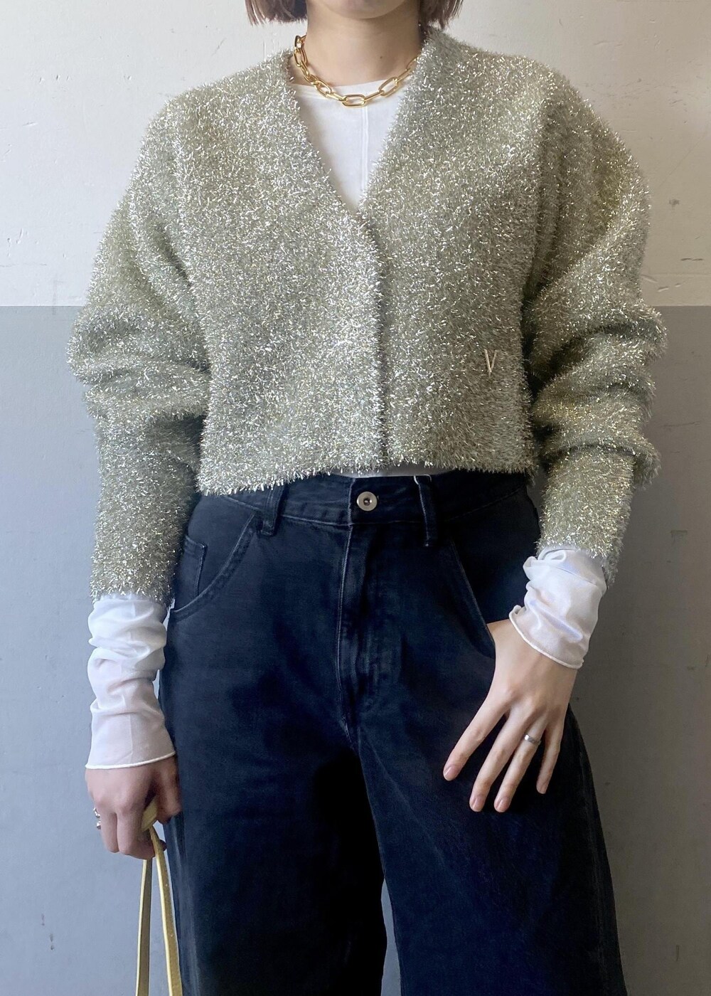 ブラック系のパンプス、ホワイト系のTシャツ/カットソー、ゴールド系のネックレスを着用したレディースの冬コーディネートの5枚目の写真