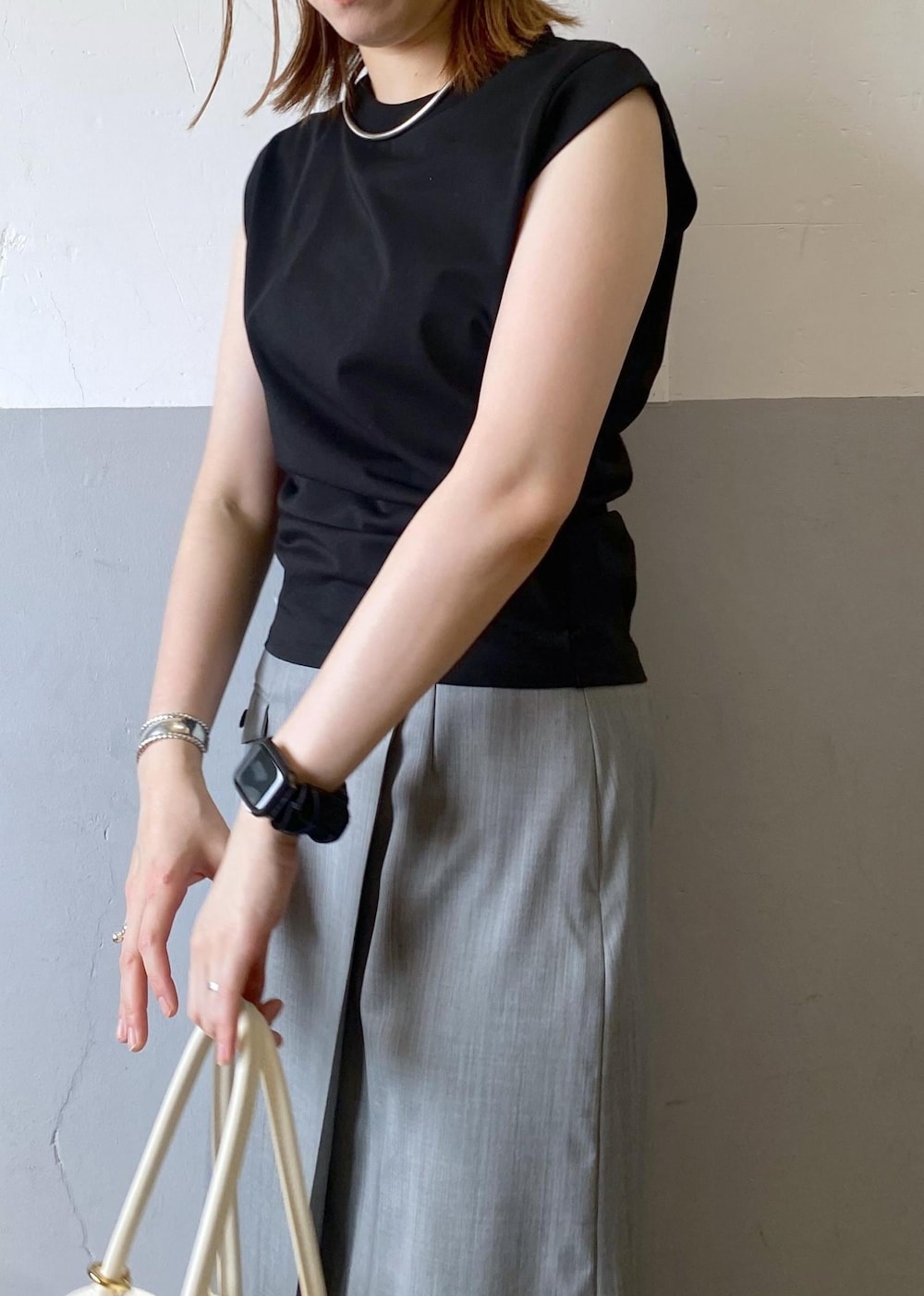 ブラック系のサンダル、グレー系のスカート、ブラック系のタンクトップを着用したレディースの夏コーディネートの8枚目の写真