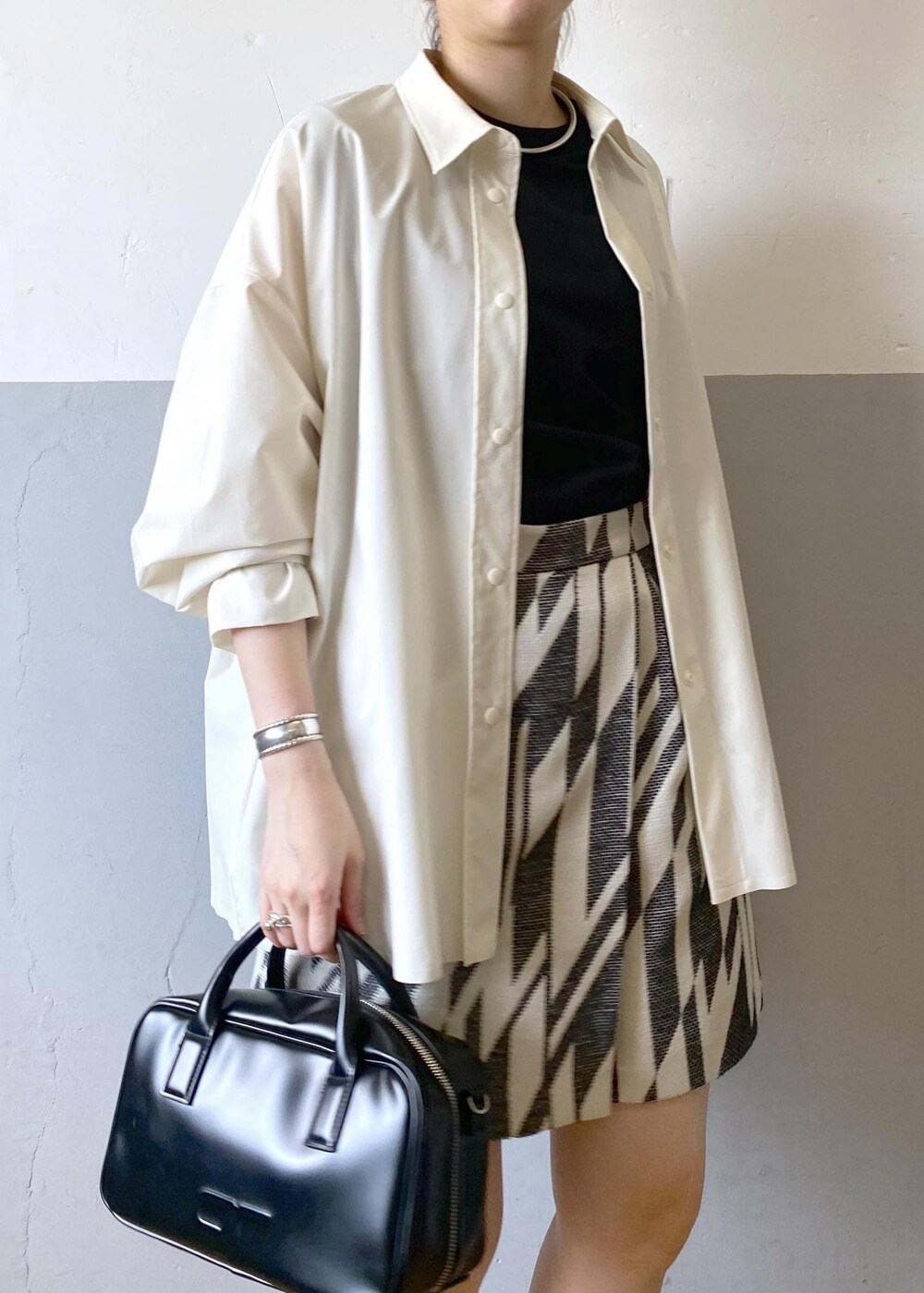 ブラック系のサンダル、ブラック系のボストンバッグ、ブラック系のタンクトップを着用したレディースの春コーディネートの7枚目の写真