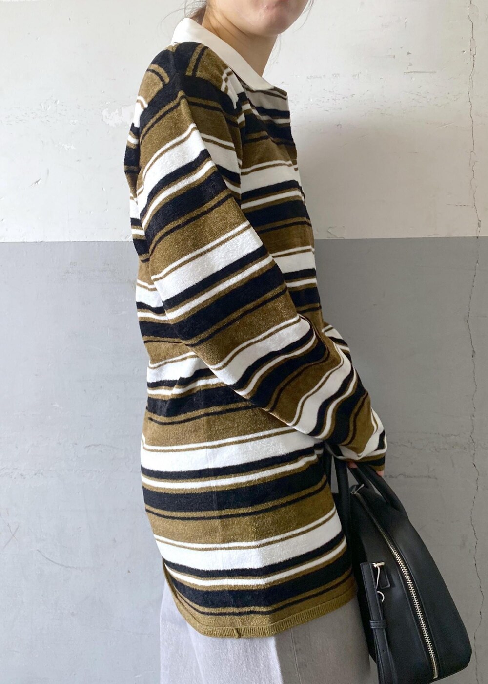 ブラック系のブーツ、ブラック系のボストンバッグ、グリーン系のワンピースを着用したレディースの秋コーディネートの9枚目の写真