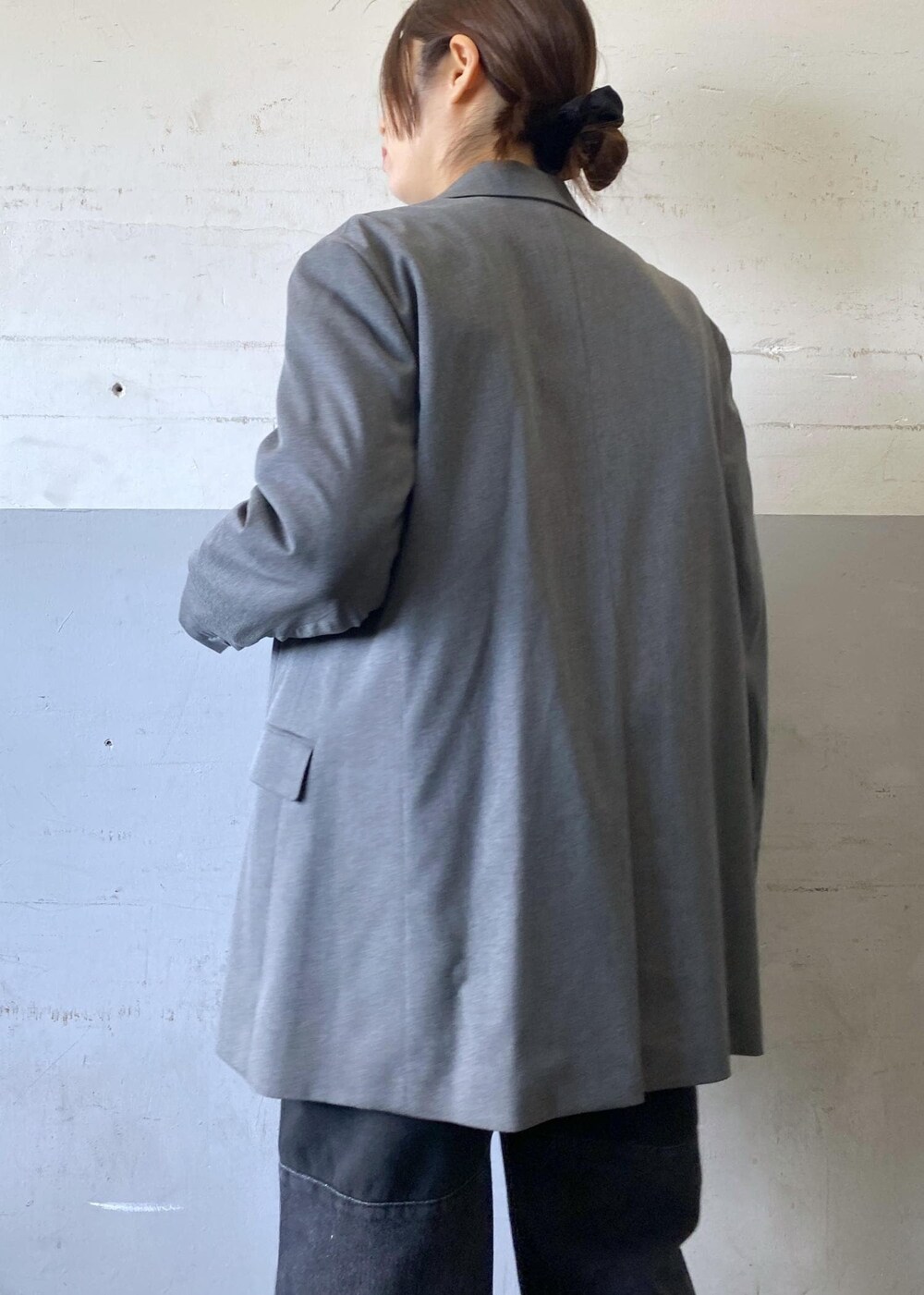 グレー系のテーラードジャケット、ブラック系のパンプス、ブラック系のショルダーバッグを着用したレディースの冬コーディネートの7枚目の写真