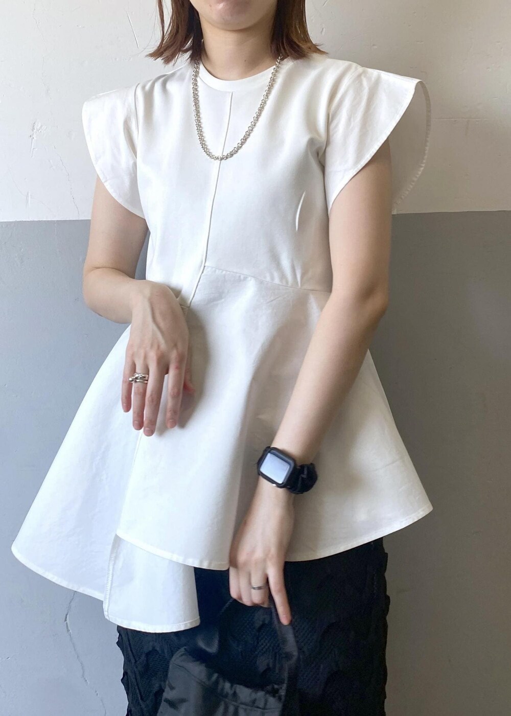 ブラック系のハンドバッグ、グリーン系のサンダル、ブラック系のスカートを着用したレディースの春コーディネートの5枚目の写真