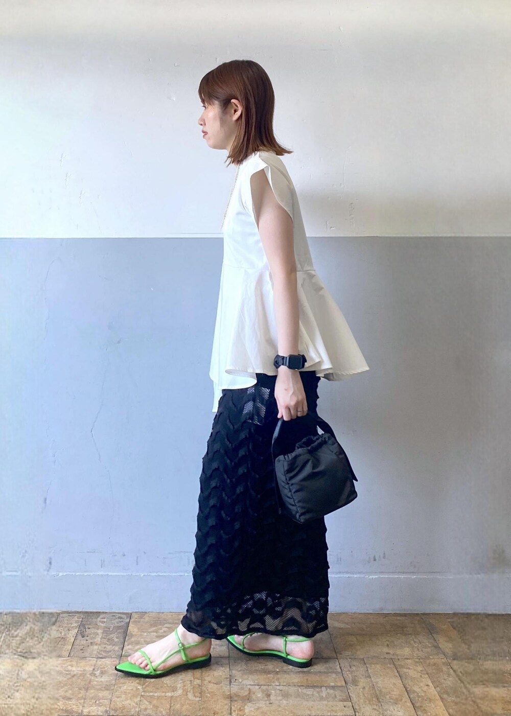 ブラック系のハンドバッグ、グリーン系のサンダル、ブラック系のスカートを着用したレディースの春コーディネートの4枚目の写真