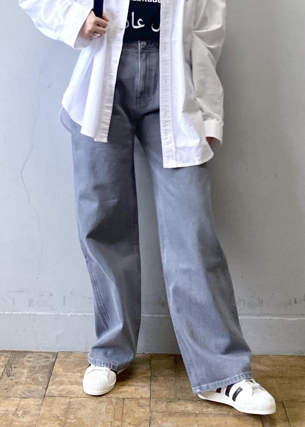 ブラック系のTシャツ/カットソー、ブラック系のショルダーバッグ、ホワイト系のシャツ/ブラウスを着用したレディースの冬コーディネートの6枚目の写真