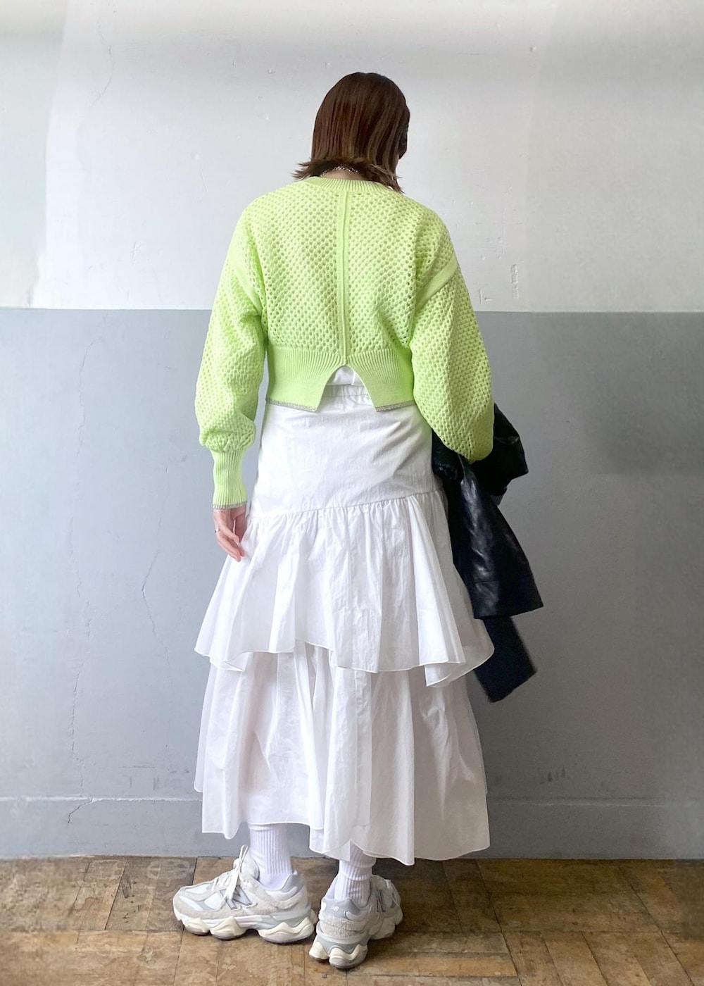 ホワイト系のスカート、ブラック系のブルゾン、グリーン系のニット/セーターを着用したレディースの春コーディネートの5枚目の写真