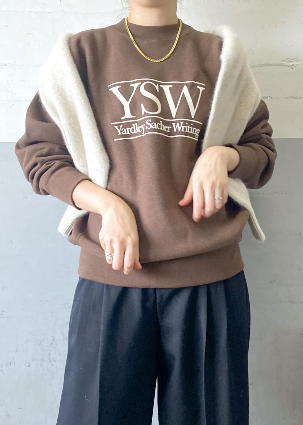 ホワイト系のパンプス、ブラック系のスラックス、ブラック系のボストンバッグを着用したレディースの秋コーディネートの6枚目の写真
