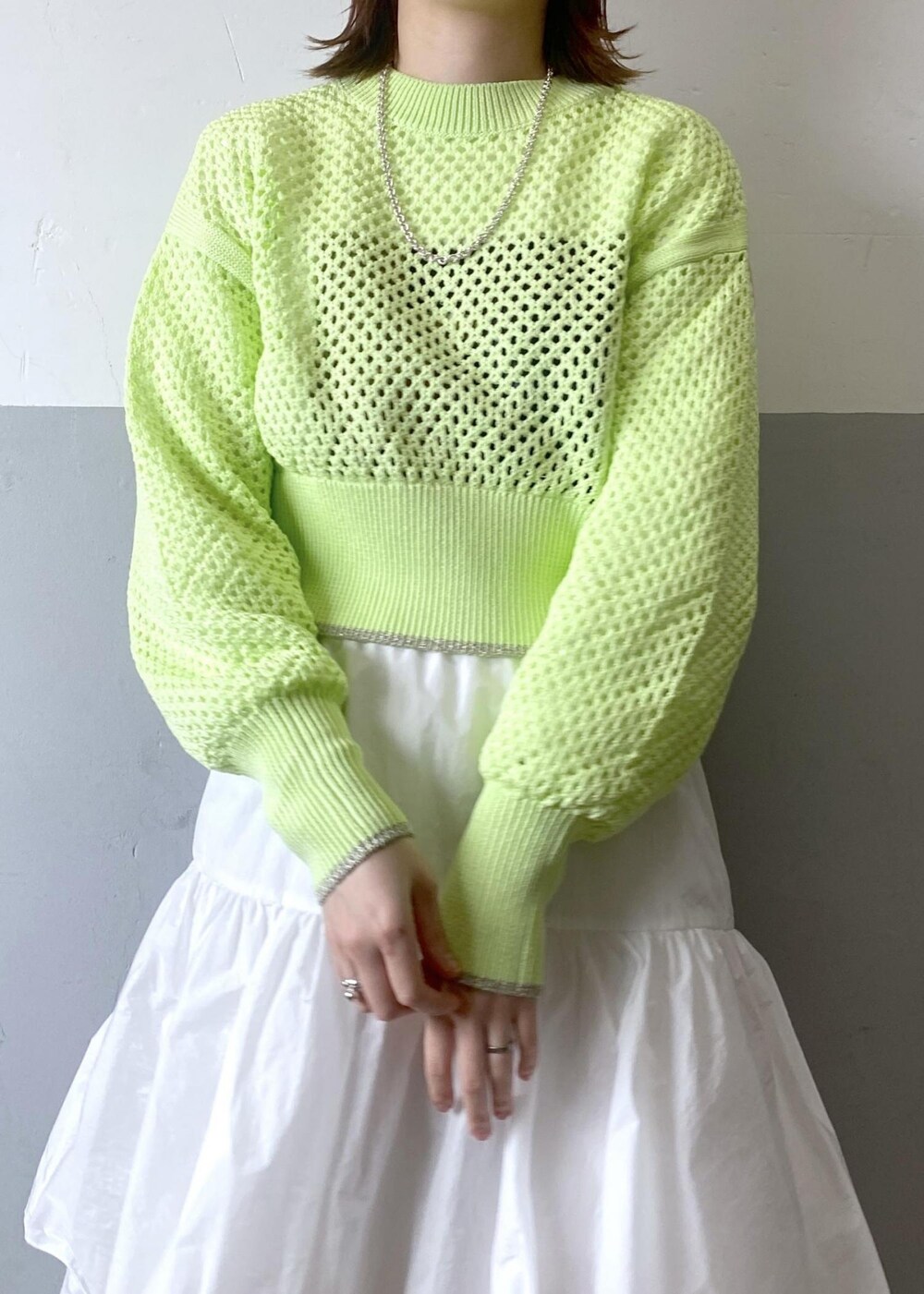 ホワイト系のスカート、ブラック系のブルゾン、グリーン系のニット/セーターを着用したレディースの春コーディネートの6枚目の写真