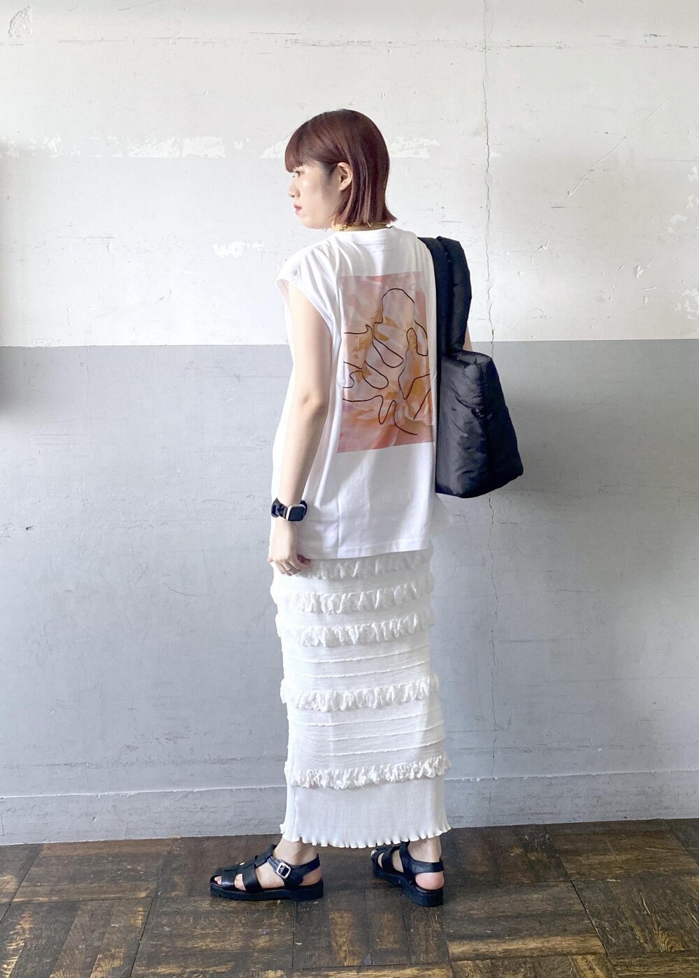 ブラック系のサンダル、ホワイト系のスカート、ホワイト系のTシャツ/カットソーを着用したレディースの夏コーディネートの10枚目の写真