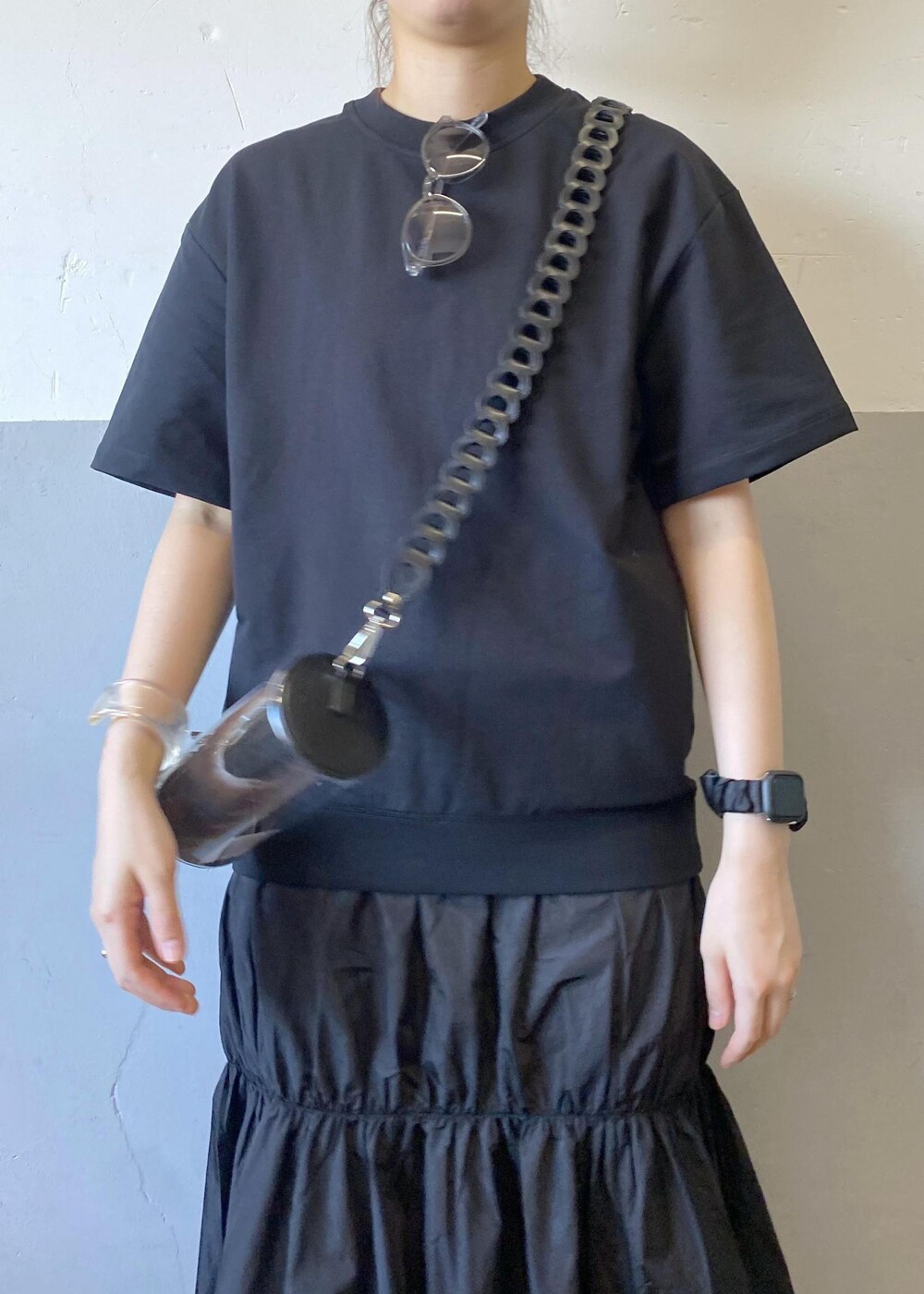 ブラック系のスニーカー、ブラック系のドラムバッグ、ブラック系のワンピースを着用したレディースの夏コーディネートの6枚目の写真