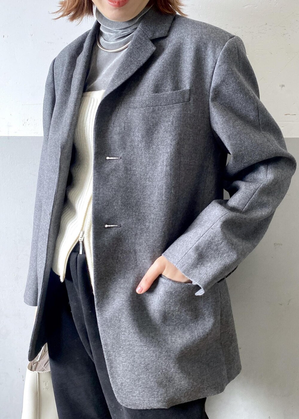 ホワイト系のショルダーバッグ、ブラック系のその他パンツ、グレー系のテーラードジャケットを着用したレディースの秋コーディネートの6枚目の写真