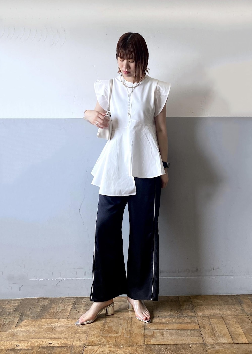 ホワイト系のショルダーバッグ、ブラック系のその他パンツ、ホワイト系のTシャツ/カットソーを着用したレディースの夏コーディネートの5枚目の写真