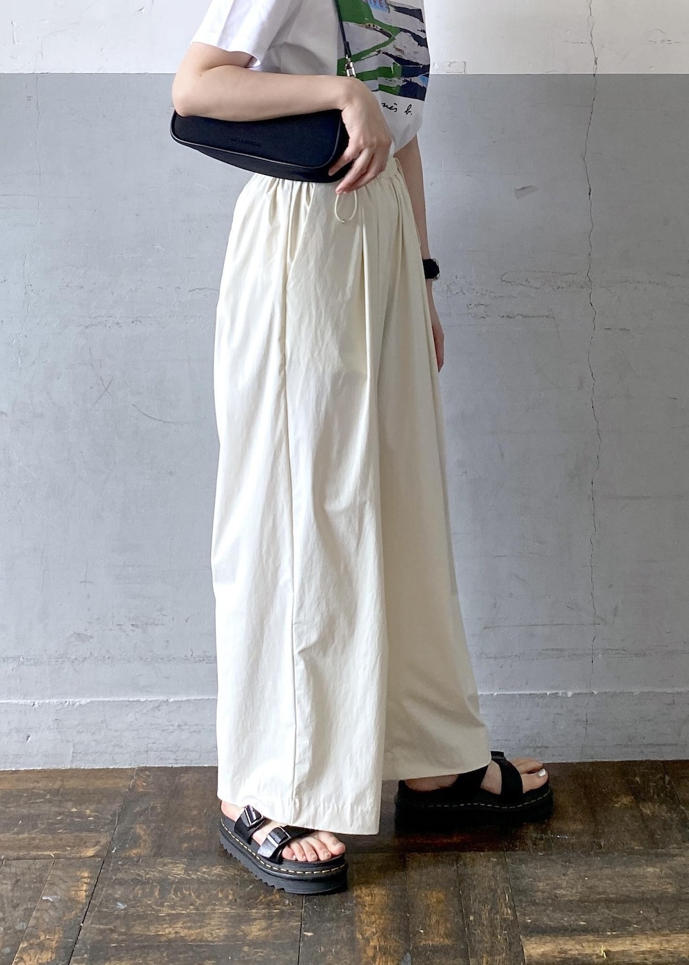 ブラック系のショルダーバッグ、ホワイト系のTシャツ/カットソーを着用したレディースの夏コーディネートの6枚目の写真