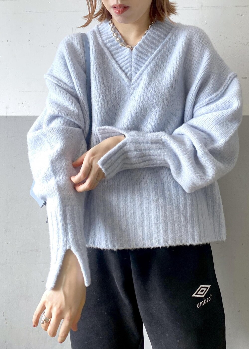 ブルー系のニット/セーター、ブラック系のその他パンツ、ブルー系のショルダーバッグを着用したレディースの秋コーディネートの5枚目の写真