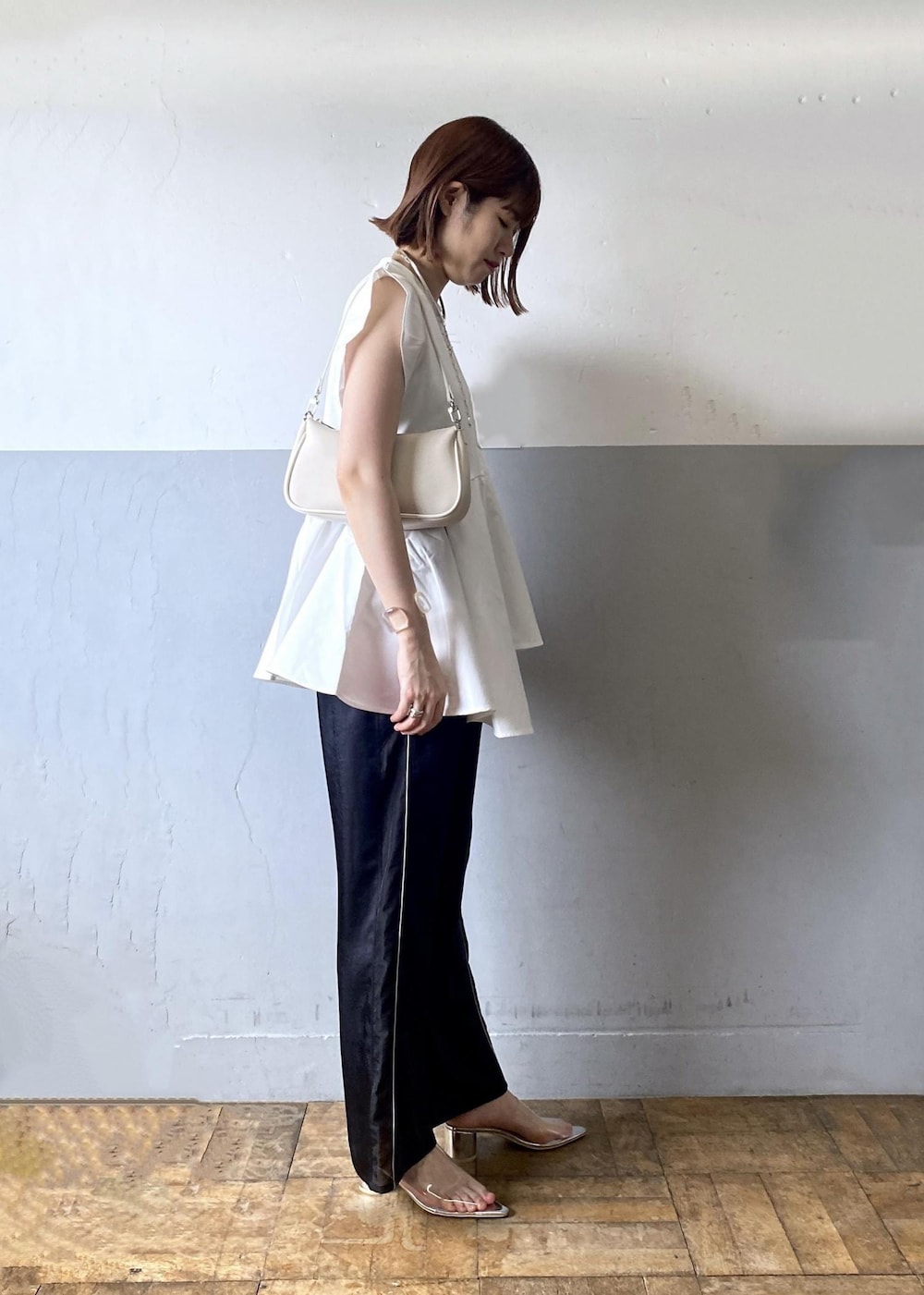 ホワイト系のショルダーバッグ、ブラック系のその他パンツ、ホワイト系のTシャツ/カットソーを着用したレディースの夏コーディネートの4枚目の写真