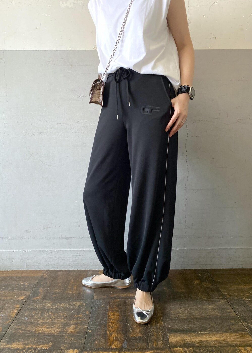 シルバー系のバレエシューズ、ホワイト系のTシャツ/カットソー、その他のショルダーバッグを着用したレディースの夏コーディネートの6枚目の写真