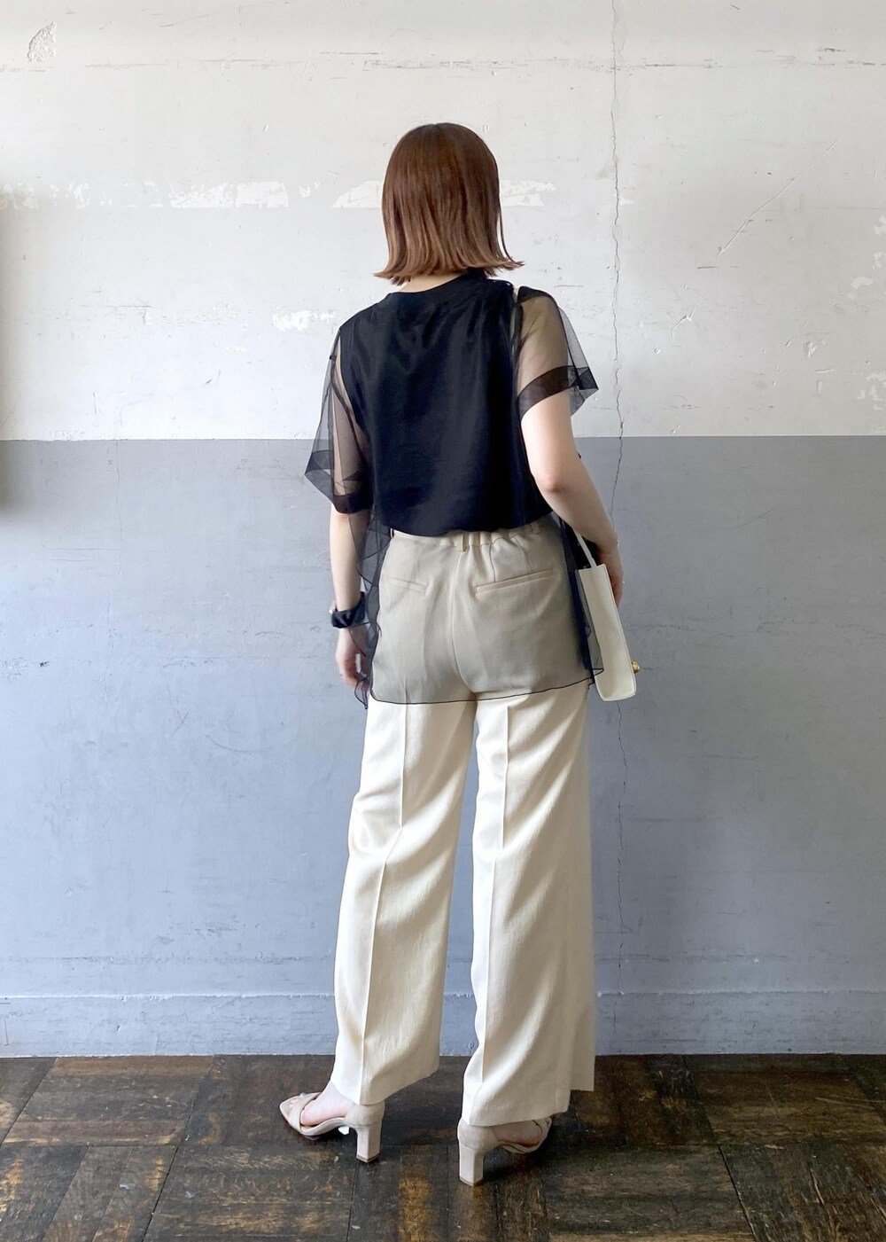 グレー系のショルダーバッグ、ベージュ系のサンダル、ベージュ系のスラックスを着用したレディースの夏コーディネートの3枚目の写真