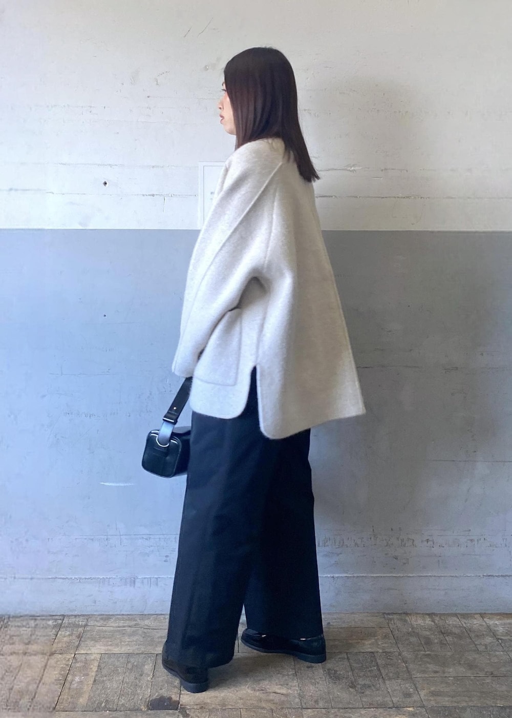 ホワイト系のカーディガン/ボレロ、ホワイト系のニット/セーター、ブラック系のハンドバッグを着用したレディースの冬コーディネートの4枚目の写真